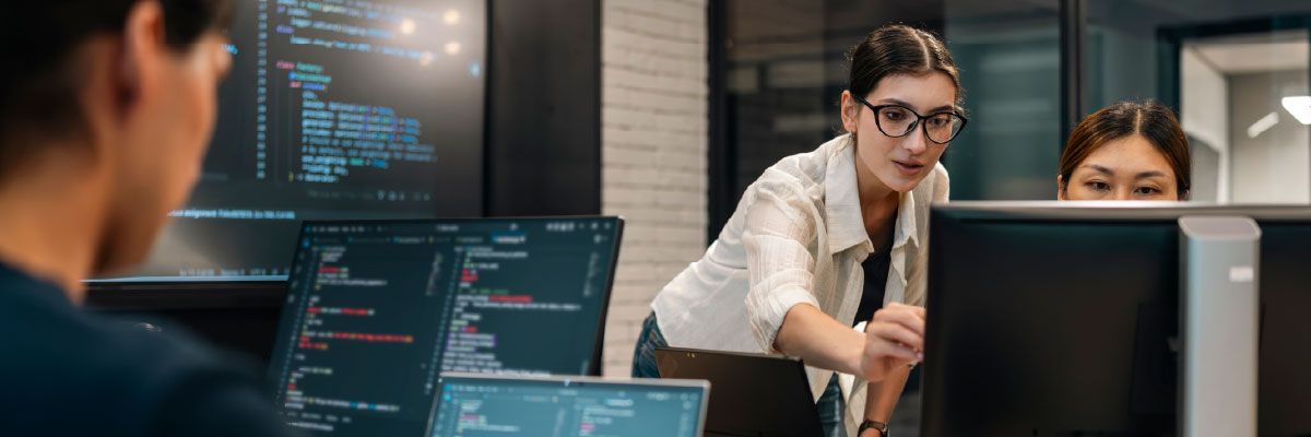 Entwicklerteam analysiert Code an Monitoren im Büro