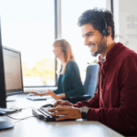 Mann mit Headset arbeitet am Computer im Büro.