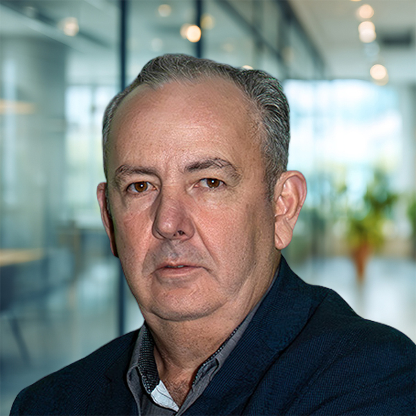 Mann in Büro, ernst dreinblickend, zeigt Porträtfoto.