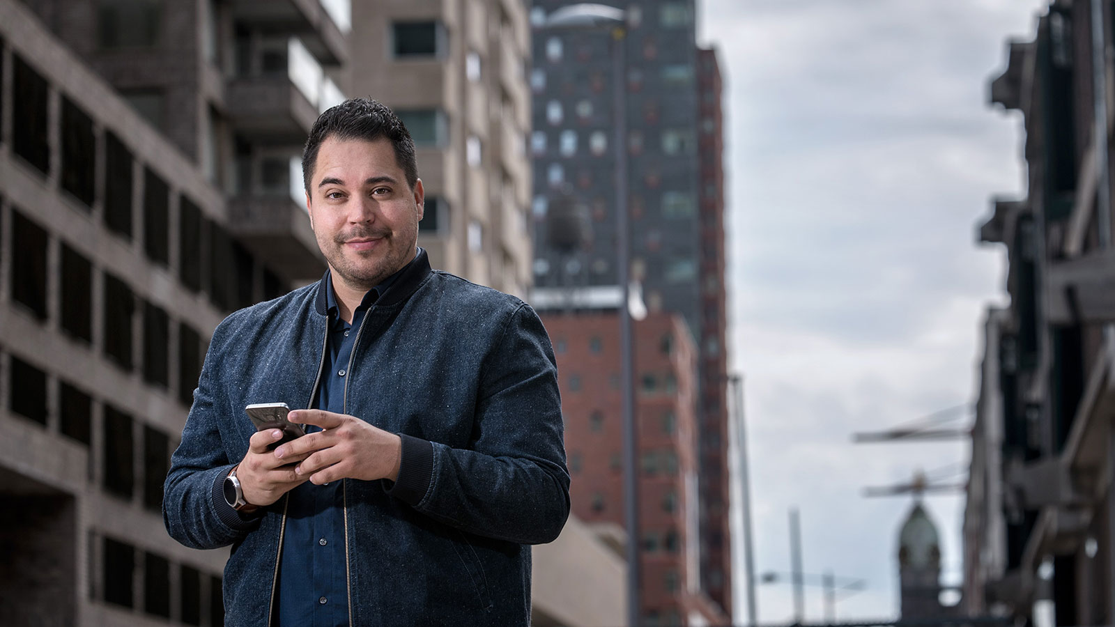 Mann in Stadt hält Smartphone in der Hand
