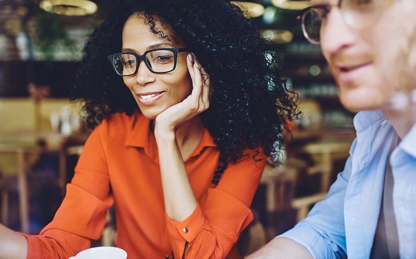 Mujer y hombre, ambos con lentes, en una reunión informal.