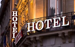 Balcón en fachada de hotel con el aviso de la palabra hotel. Control de la inflación en programas hoteleros