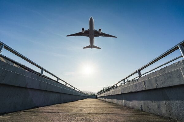Avión despegando, visto desde un puente. Artículo sobre gestión de tarifas por parte de un gestor de viajes corporativos.