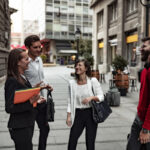 Group of professionals chatting on a city street.
