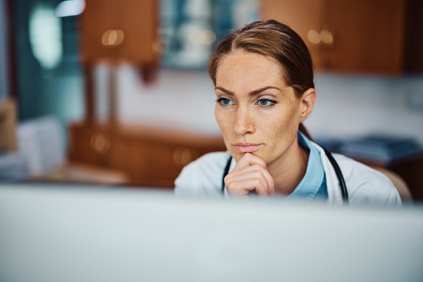 Doctor reviewing information on computer screen thoughtfully