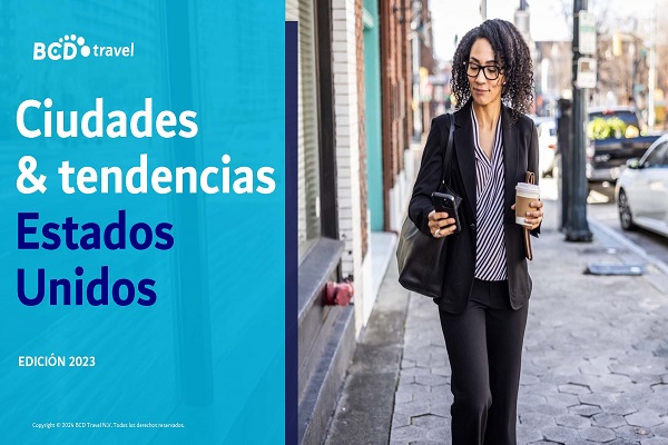 Portada del informe Ciudades y tendencias Estados Unidos 2023, que muestra a una mujer ejecutiva caminando mientras mira el celular y lleva un vaso de café en la otra mano.
