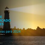 Portada del informe del mercado de viajes 2024. Se ve un faro encendido y, al fondo, las siluetas de dos personas caminando en una playa rocosa, en el atardecer.