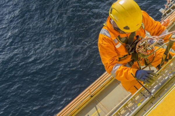 employee on yellow suit working close to the sea