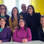 Un grupo de empleados de BCD en Italia, conformado por seis mujeres y un hombre, miran sonrientes a la cámara.