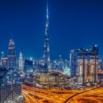 Imagen nocturna de la ciudad de Dubai, en Emiratos Árabes Unidos. Se ven los edificios y las autopistas iluminadas. En el centro, sobresale el edificio Burj Khalifa, el más alto del mundo.