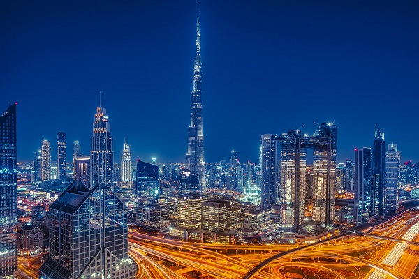 Imagen nocturna de la ciudad de Dubai, en Emiratos Árabes Unidos. Se ven los edificios y las autopistas iluminadas. En el centro, sobresale el edificio Burj Khalifa, el más alto del mundo.