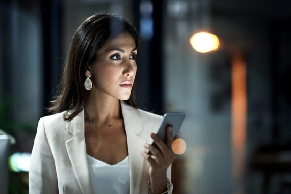 Mujer ejecutiva consulta el celular. Preocupaciones de las mujeres que viajan.