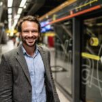 Hombre sonriendo en una estación de metro.