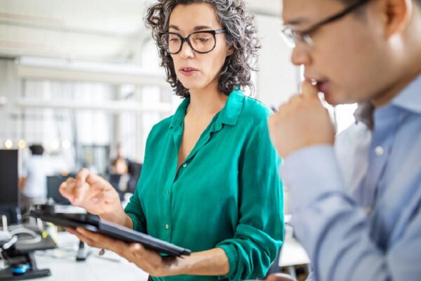 Hombre y ,mujer en oficina analizando cifras. Nuevo estudio de BCD Travel revela poco conocimiento de la norma para gestionar los riesgos en los viajes.