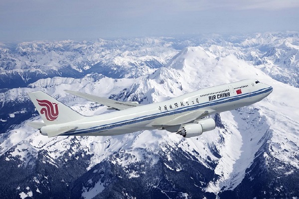 Un avión blanco, con el logo de Air China en la cola, vuela sobre una cadena montañosa nevada.