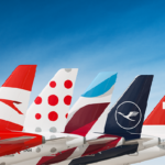 Se ven las colas y alerones traseros de cinco aviones, cada uno de ellos con los colores distintivos y logos de las aerolíneas de Lufthansa.