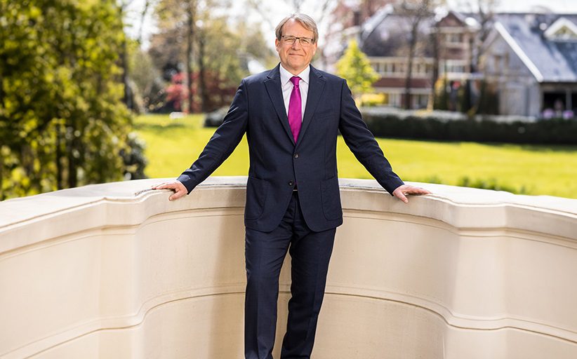 Stephan Baars, presidente y CEO de BCD Travel, con traje elegante, de pie y con las manos apoyadas en un muro.