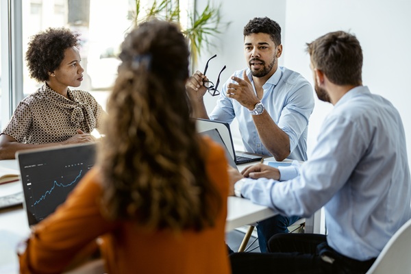 Colleagues discussing financial chart during office meeting