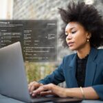 Woman working on laptop with city info overlay.