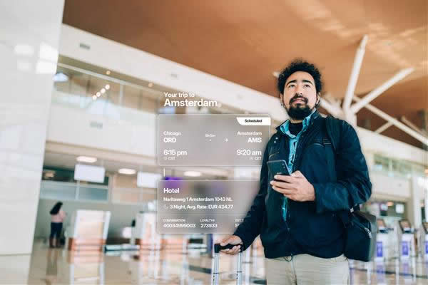 Traveler at airport with flight information display.