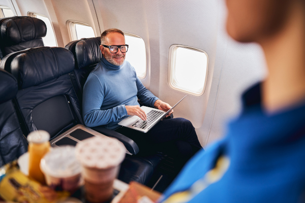 Man working on laptop during airplane flight