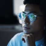 Person with glasses looking at computer screen