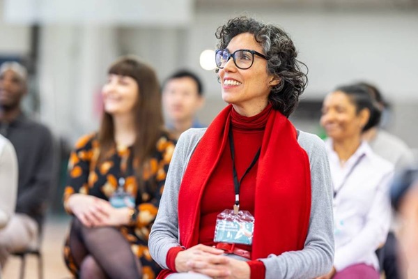 Smiling woman with glasses and red scarf at workshop