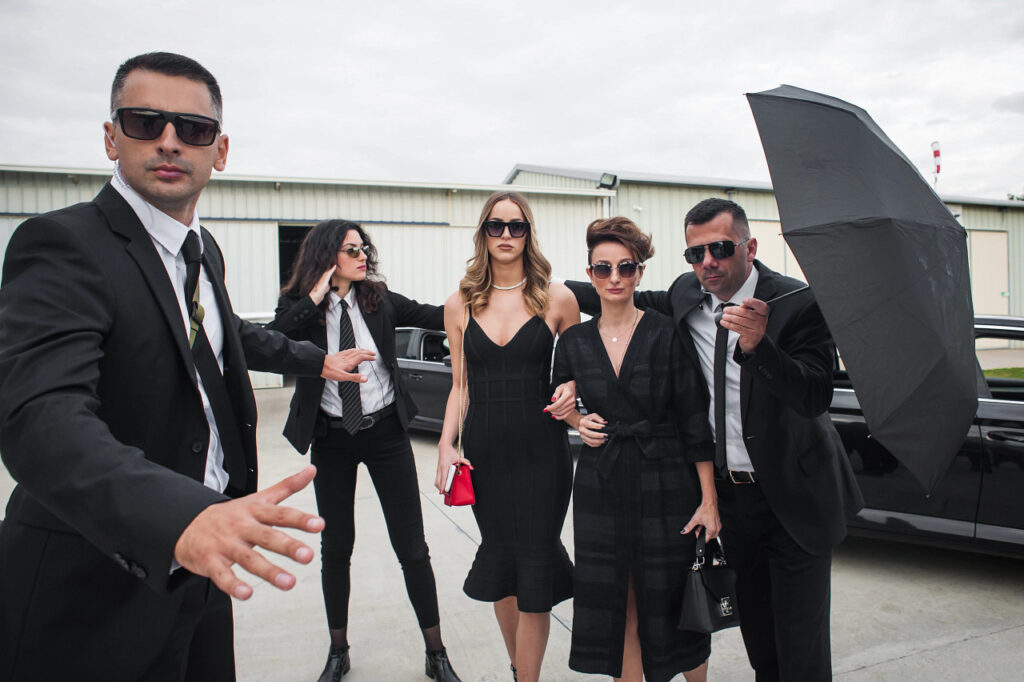 Female celebrity is being escorted by security guards and bodyguards from the airplane to a limousine