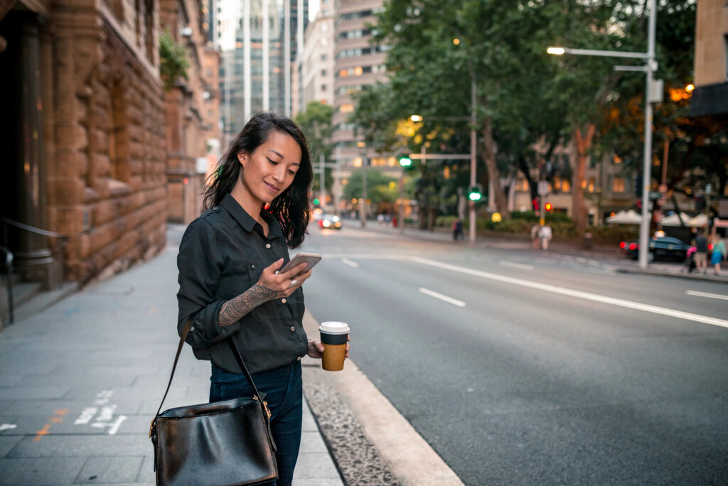 Woman using her mobile phone to check her travel and payment details