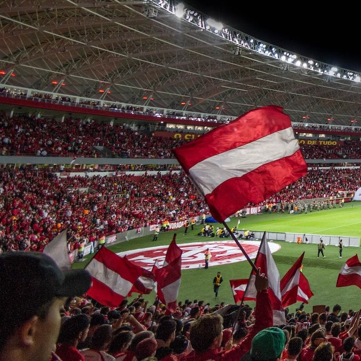 Fans wave red and white flags in packed stadium