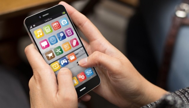 Persoon gebruikt smartphone met kleurrijke apps.