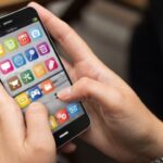 Handen houden smartphone met diverse apps geopend