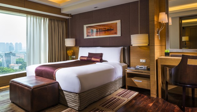 Luxe hotelkamer met groot bed en raamzicht.