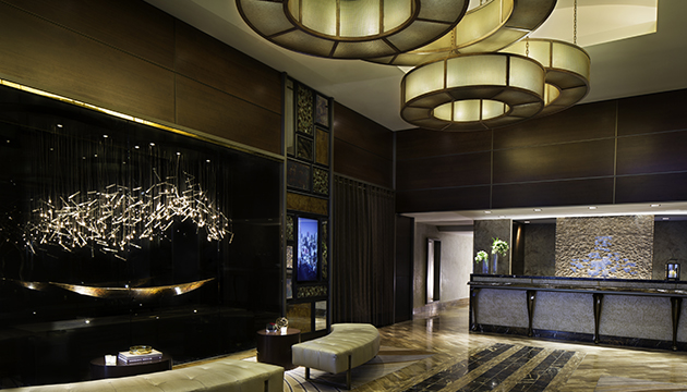 Moderne hotel lobby met kunstverlichting en receptie.