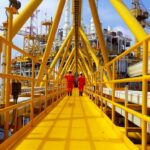 Twee arbeiders op offshore olieplatform brugpad