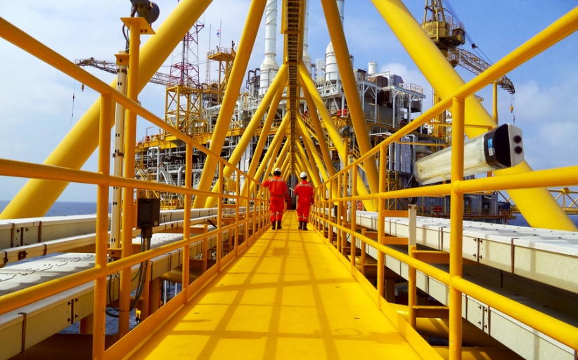 Twee arbeiders op offshore olieplatform brugpad