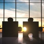 Mensen duwen puzzelstukken voor grote ramen samen