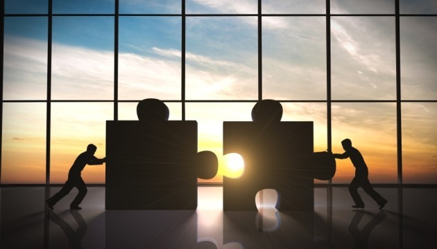 Mensen duwen puzzelstukken voor grote ramen samen