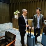 Twee mannen met koffers in hotelreceptie