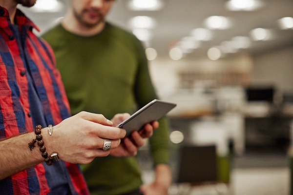 Two people discussing with a tablet in office.