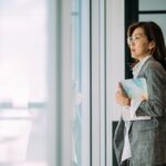 Professional woman in office holding a folder.