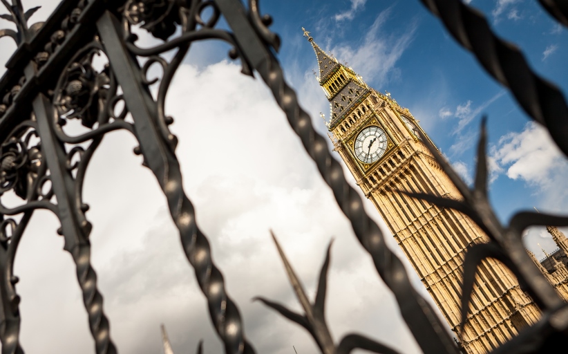 Big Ben achter smeedijzeren hekwerk, bewolkte hemel