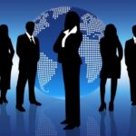 Silhouetten van zakenmensen voor wereldbol achtergrond.