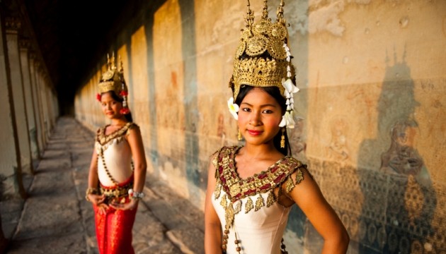 Twee vrouwen in traditionele kleding bij historische muur.