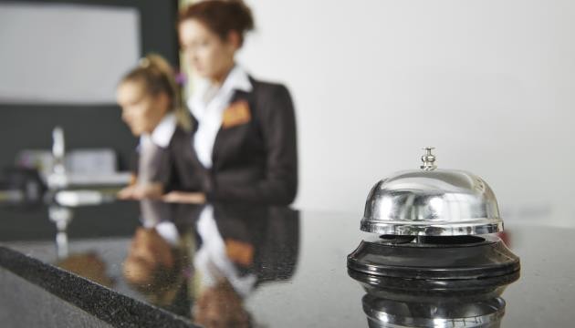Hotelreceptie met bel en receptionisten