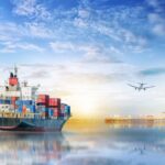 Containerschip en vliegtuig bij zonsondergang in haven.