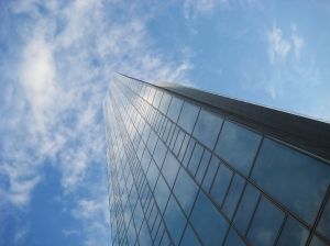 Hoge glazen wolkenkrabber tegen blauwe lucht