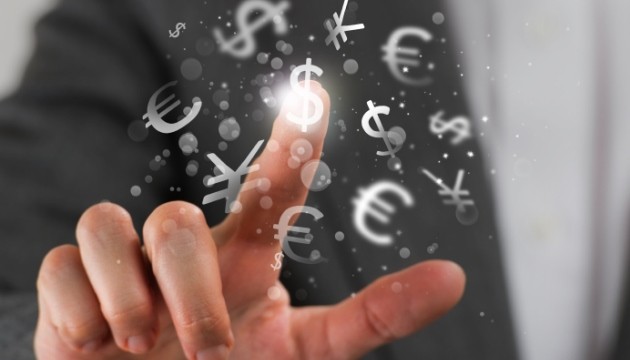 Vinger wijst naar internationale valuta symbolen in de lucht.