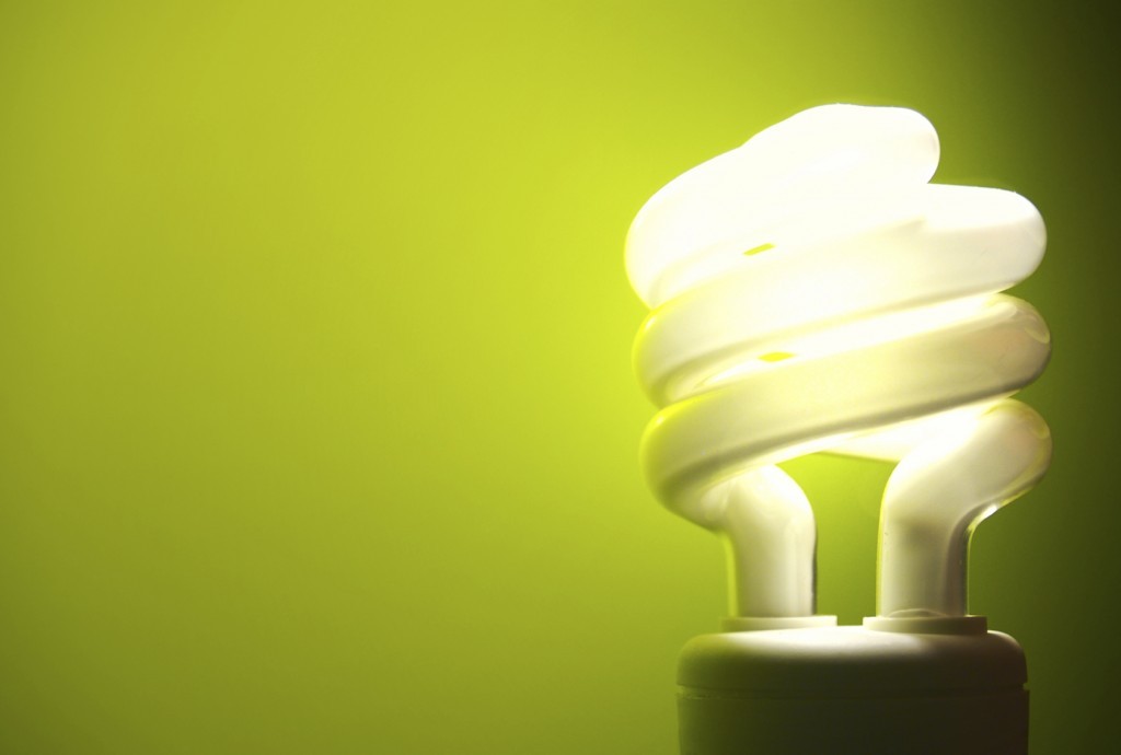 Energiezuinige spiraalvormige lamp op groene achtergrond