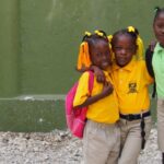 Kinderen in schooluniforms buiten schoolgebouw